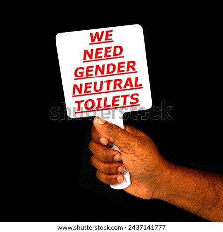 WE NEED GENDER NEUTRAL TOILETS Signed board holding hand on black background close-up view, Human rights concept photography, Hand holding a board by protester