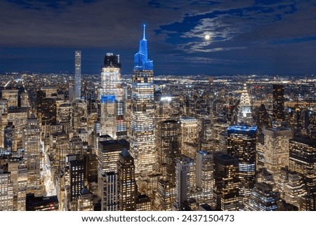 New York City aerial night view, full moon and illuminated skyscrapers. Moonrise over Midtown Manhattan skyline
