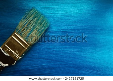 A brush on a blue nacreous color painted background. Abstract background. Royalty-Free Stock Photo #2437151725