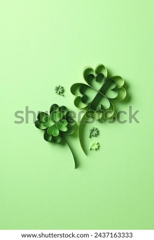 St Patricks day four leaf clover paper cut on green background.