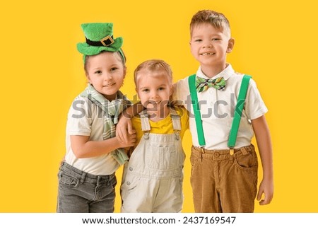 Cute kids with leprechaun's hat on yellow background. St. Patrick's Day celebration