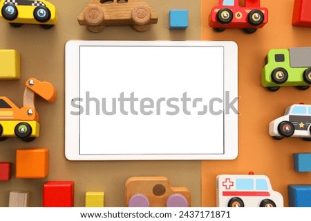 Modern tablet and toys on color background, flat lay. Space for text