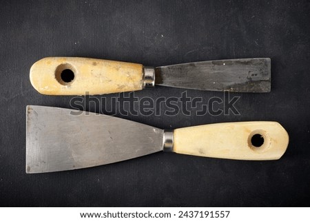 Close up of two old disused trowels on a work bench Royalty-Free Stock Photo #2437191557