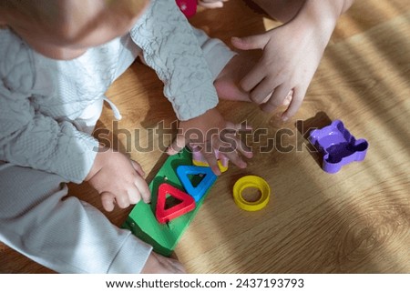 Childrens wooden toy. Childrens hands close-up with educational logic toys for kids