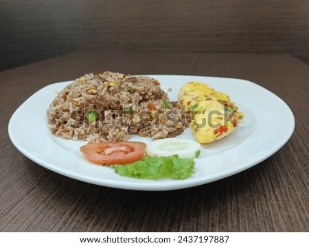 A plate of black pepper beef fried rice with an omelet