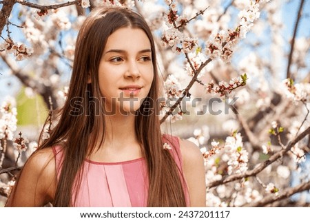 Close up portrait of a young beautiful girl in a blooming garden