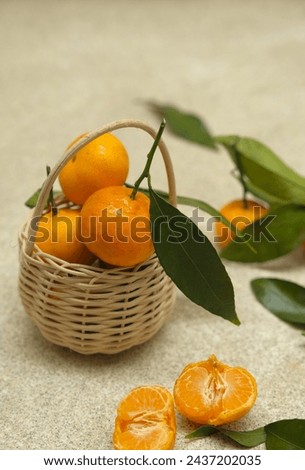Small oranges fruit or tangarine in rattan basket with brown background. Jeruk Royalty-Free Stock Photo #2437202035