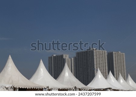 the combination of the roof of the tent and the building forms an interesting composition
