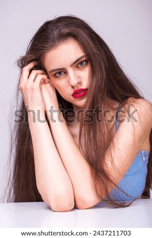 Close up portrait of a young beautiful happy brunette woman in blue dress, isolated on white background