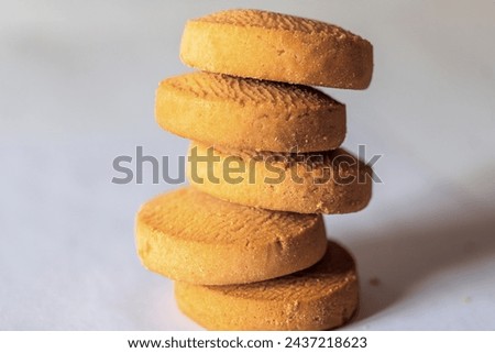 A mouthwatering close-up photo featuring a tempting stack of round, golden brown cookies