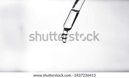 A dropper with cosmetic oil close up on a white glowing background. Cosmetic procedures. Serum