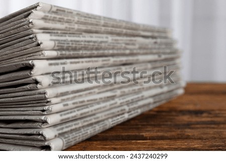 Stack of newspapers on wooden table, closeup. Journalist's work