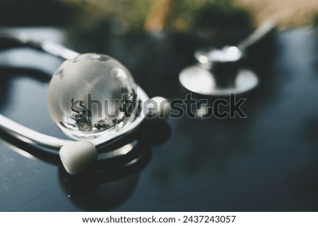 close up glass globe and stethoscope on table, world health day, medical and healthcare, telemedicine and climate change, global pandemic crisis risk and problem concept