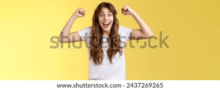 Lucky girl feeling like winner. Triumphing excited cheerful young woman raise hands fist pump up celebratory smiling broadly thrilled yelling supportive root favorite team reach success. Royalty-Free Stock Photo #2437269265