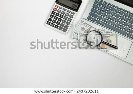 Top view of laptop and calculator with dollars on white background with copy space.