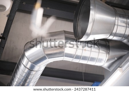 Industrial metal air flow and air conditioning pipes on the ceiling of an industrial factory. keeping the air fresh and clean for health and safety purposes. Healthy clean working environment 