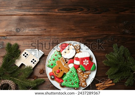 Different tasty Christmas cookies and festive decor on wooden table, flat lay. Space for text
