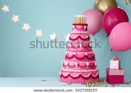 Elaborate pink tiered birthday cake with gifts and birthday balloons for a birthday party