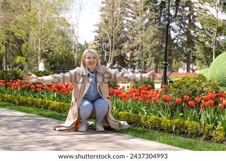 Child running into mother's hands with outstretched arms to hug her. Family having fun in the park. Girl is happy to meet her mom. Background image.
