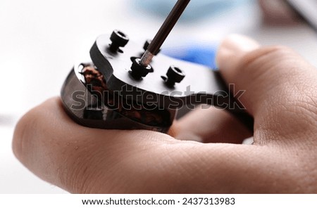 Tightening screws into carbon body of fpv DIY copter by screwdriver Royalty-Free Stock Photo #2437313983