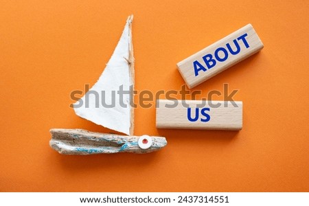 About us symbol. Concept word About us on wooden blocks. Beautiful orange background with boat. Business and About us concept. Copy space