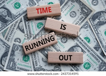 Time is running out symbol. Concept words Time is running out on wooden blocks. Beautiful dollar background. Business and Time concept. Copy space.