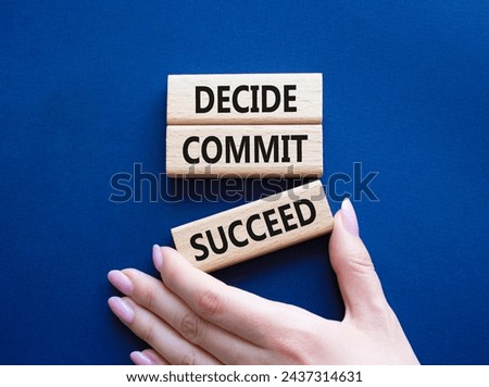 Decide Commit Succeed symbol. Concept words Decide Commit Succeed on wooden blocks. Businessman hand. Beautiful deep blue background. Business concept. Copy space.