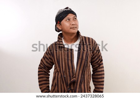 Smiling Asian man standing while looking above. Isolated on white Royalty-Free Stock Photo #2437328065