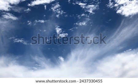 White streaky clouds like strands of hair  Royalty-Free Stock Photo #2437330455