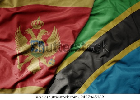 big waving national colorful flag of tanzania and national flag of montenegro . macro