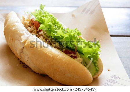 Vietnamese sandwich banh mi. It is a short baguette with thin, crisp crust and a soft, airy texture Royalty-Free Stock Photo #2437345439