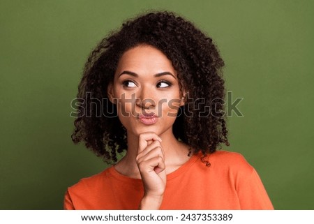 Photo portrait of pretty young girl look minded interested empty space wear trendy orange outfit isolated on khaki color background