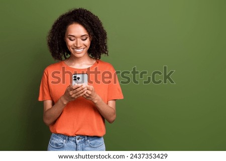 Photo of cute good mood lady dressed orange t-shirt communicating apple iphone samsung device empty space isolated khaki color background