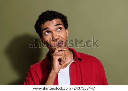 Photo of doubtful unsure man dressed red shirt arm chin looking empty space isolated green color background Royalty-Free Stock Photo #2437353447