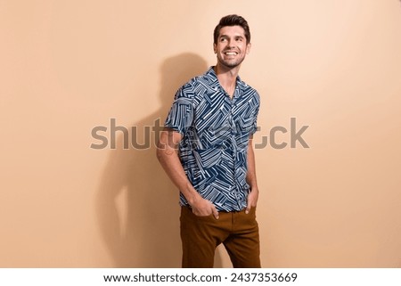 Portrait of cool confident guy with trendy hairstyle wear stylish shirt look at proposition empty space isolated on beige color background