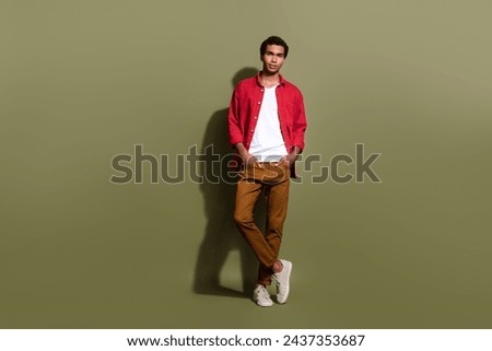 Full length photo of positive cool guy wear red shirt walking empty space isolated khaki color background