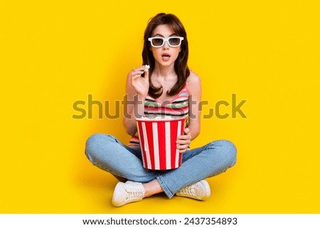 Full body photo of astonished girl wear knit tank in 3d glasses hold popcorn staring at thriller movie isolated on yellow color background