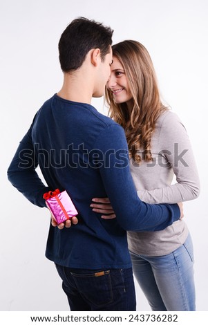 isolated studio shot of cheerful young couple man woman offering each other gifts for valentine lovers day