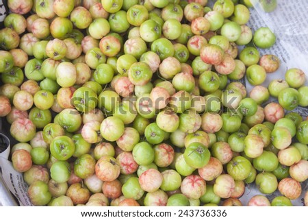 A lot of green and red star apples, at a market