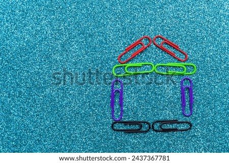 Abstract house made from office paper clips. The concept of making money on real estate. Background with selective focus and copy space