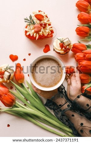 Cup of coffee, bouquet of red tulips and cake top view flat lay, festive background.