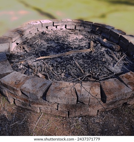 A circular outdoor fire pit made out of bricks