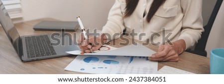 Asian businesswoman sitting and analyzing financial reports Business growth using laptop computers and documents, graphs, charts, and investment calculators. Home office business plan.