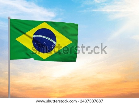 3D illustration of a Brazil flag extended on a flagpole and in the background a beautiful sky with a sunset