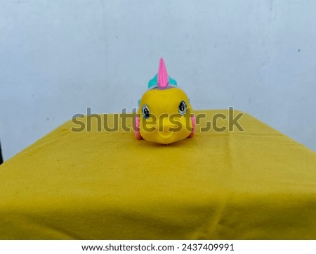 Baby plastic toy fish picture in yellow and white background 