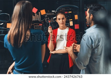 Professional businesspeople discussing,brainstorming business idea at glass wall. Group of start up team working together, planing marketing strategy or campaign. Teamwork, business plan. Tracery. Royalty-Free Stock Photo #2437426763
