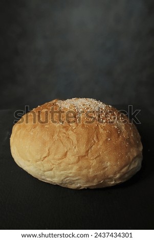 Tasty bun on black background