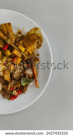 Vertical pic, Plate of rice with curry, placed on a white background, Thai food, fish curry.