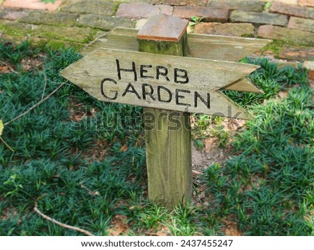 Wooden arrow sign that says Herb Garden