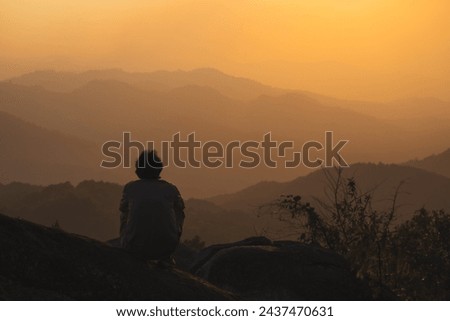 landscape and travel concept with solo freelancer man relax at top of mountain and sunset with layer of mountain